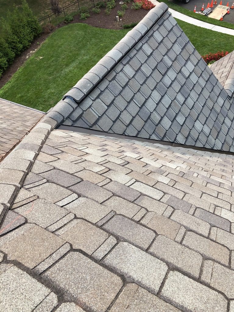 A roof with a brick pattern and a gray tile on it.