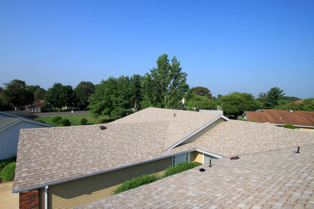a roof with newly installed tan colored roof shingles.