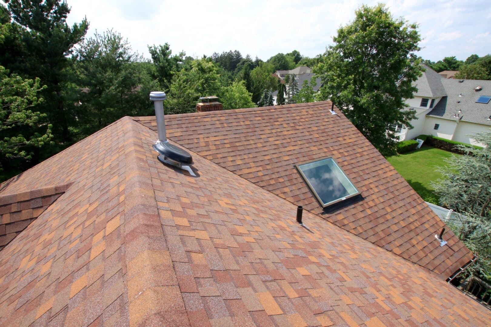 A roof with a skylight and a chimney.