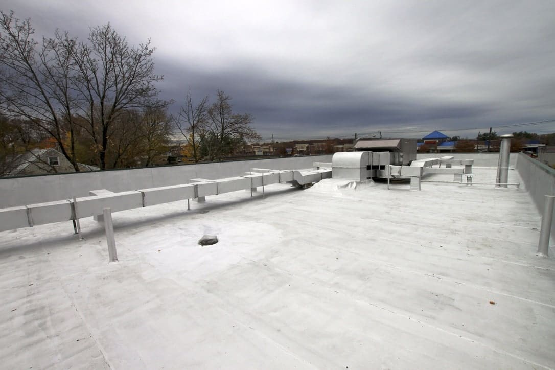 A white roof with a lot of duct work on top of a building.
