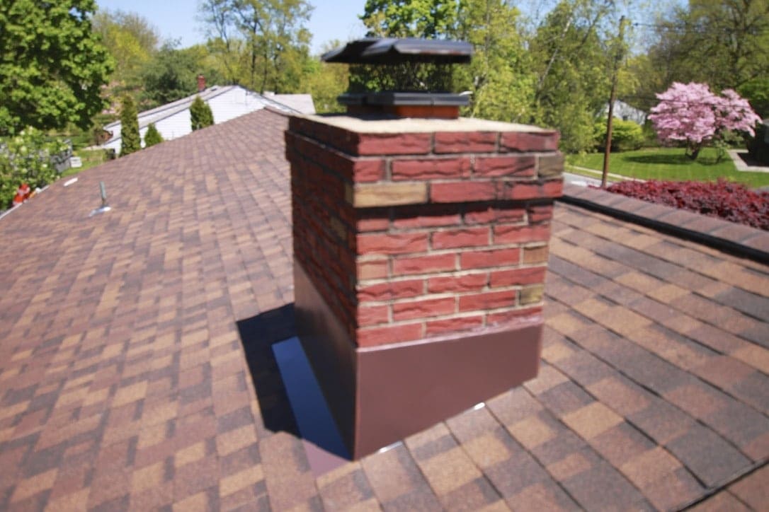 A brick chimney on the side of a roof.