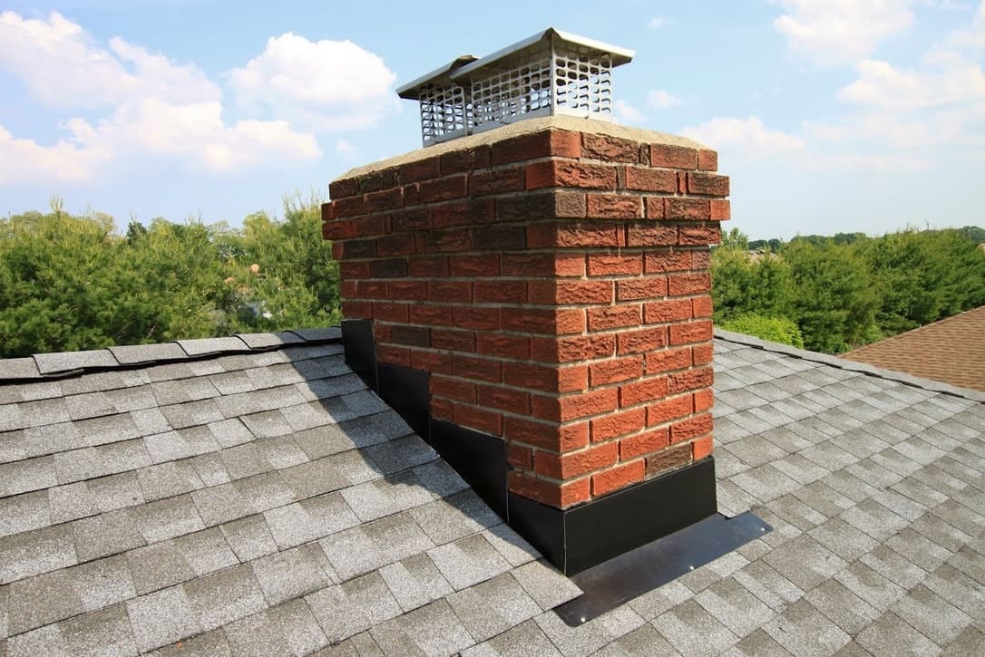 A brick chimney on the roof of a house.