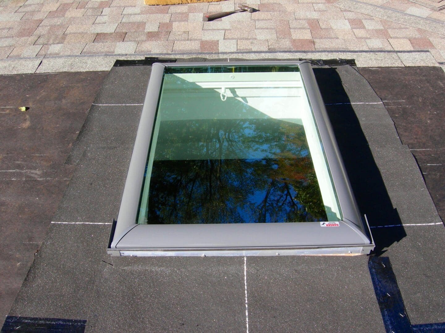 A skylight in the middle of being installed on a roof.