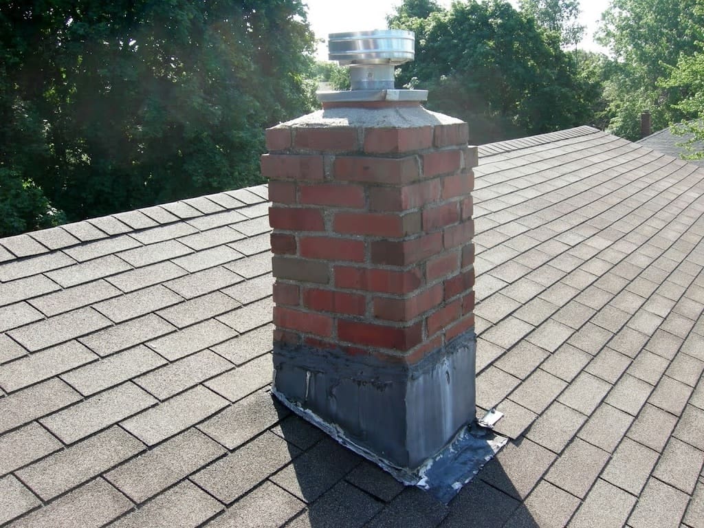 A brick chimney on the roof of a house.