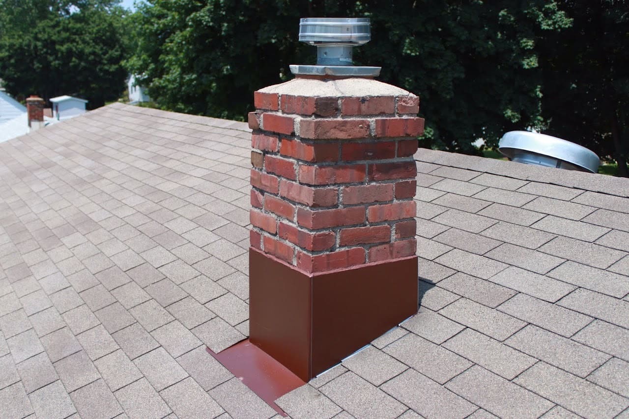 A brick chimney with a metal cap on the top.