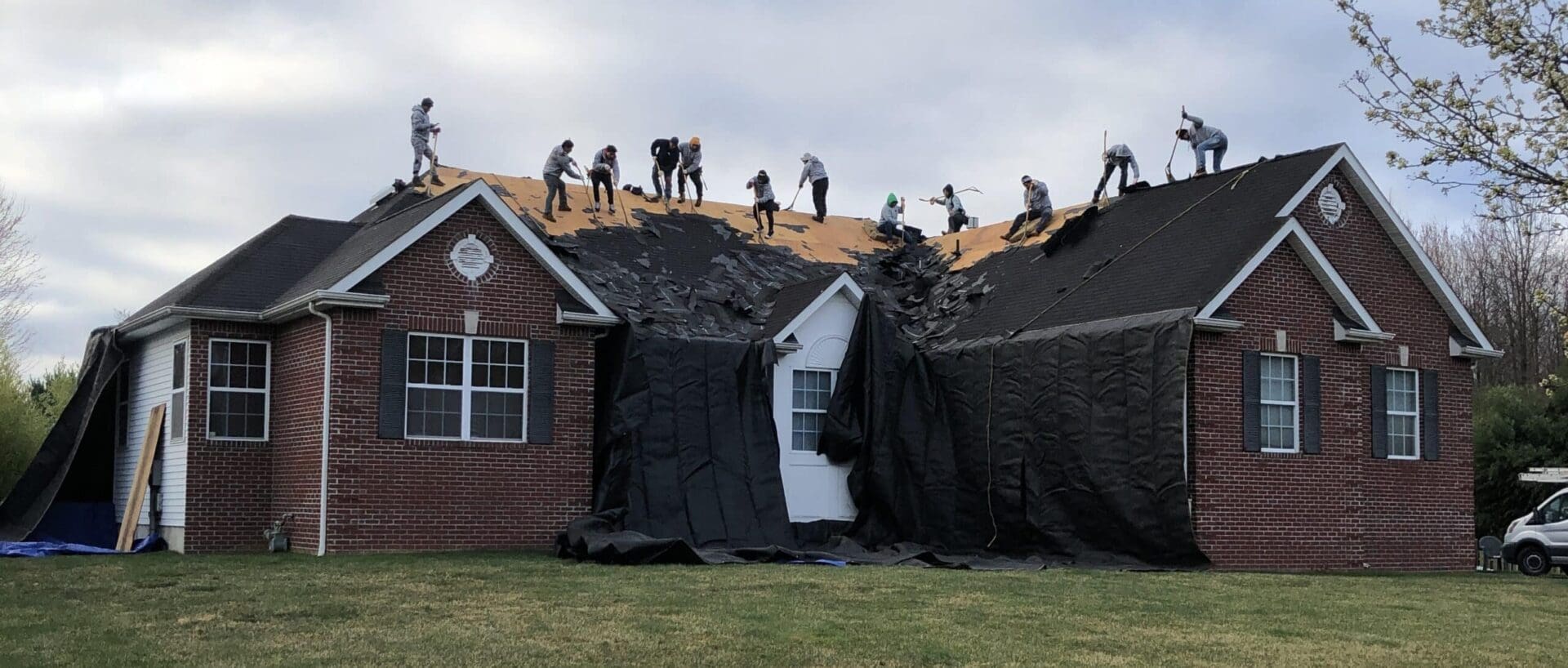 A group of people working on the roof of a house.
