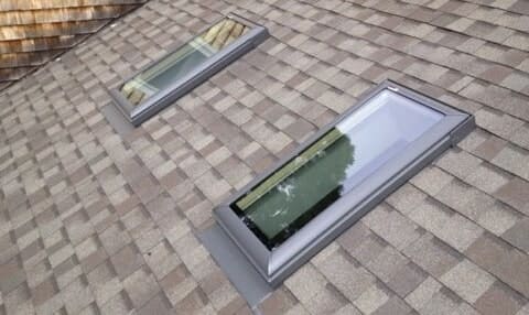 A close up of two skylights on the side of a roof