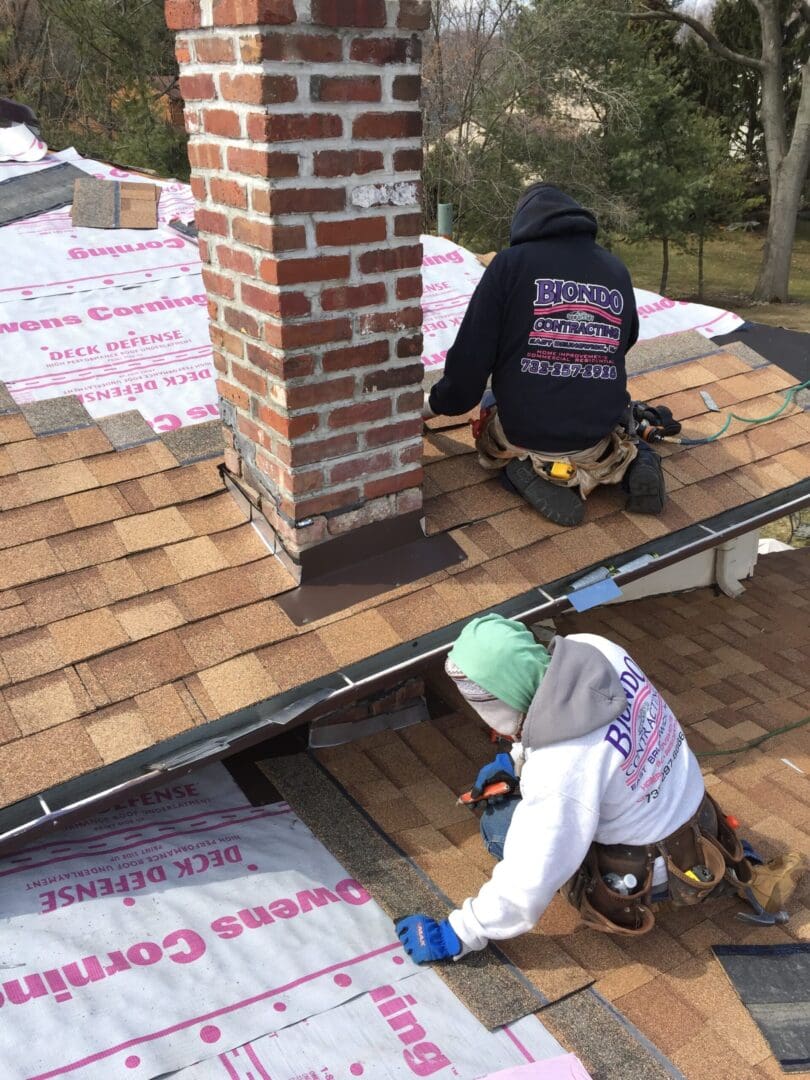 Two people working on a roof with insulation