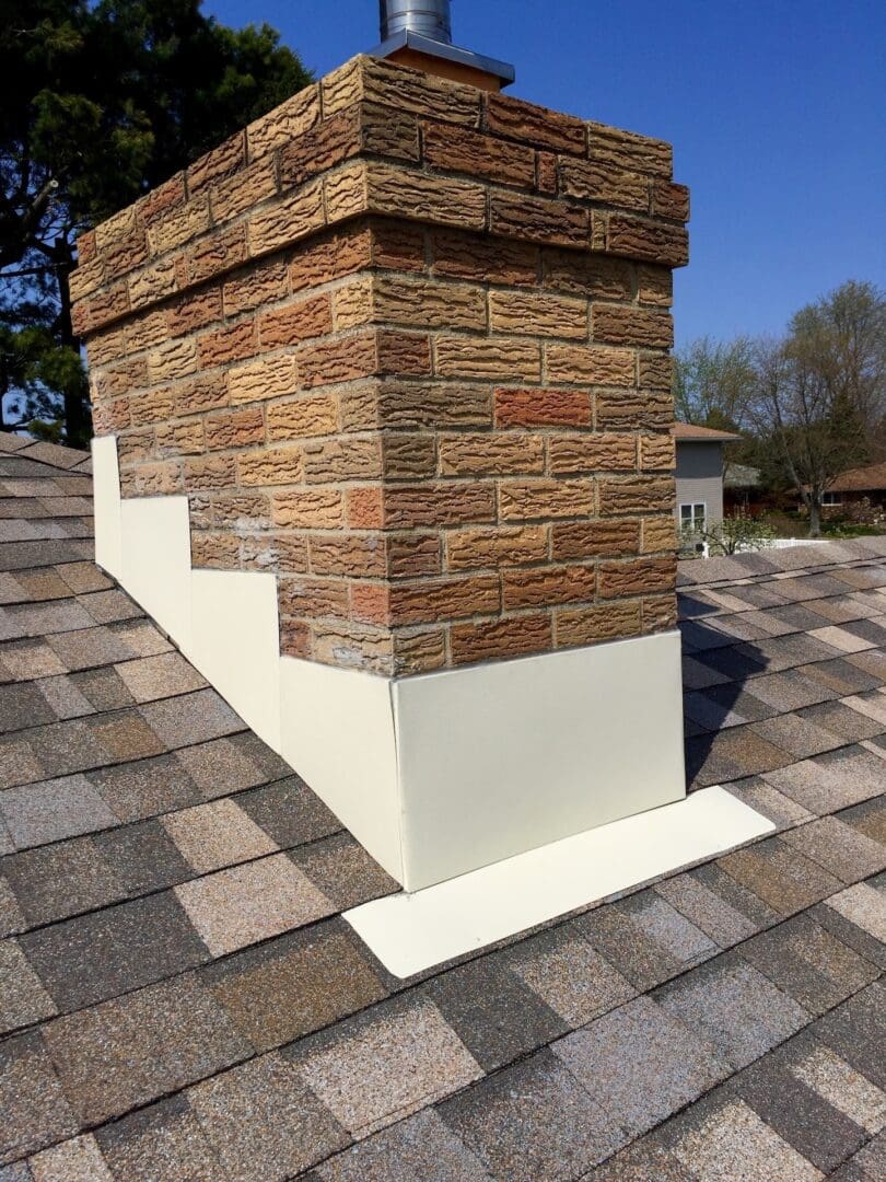 A brick chimney with new white colored flashing.
