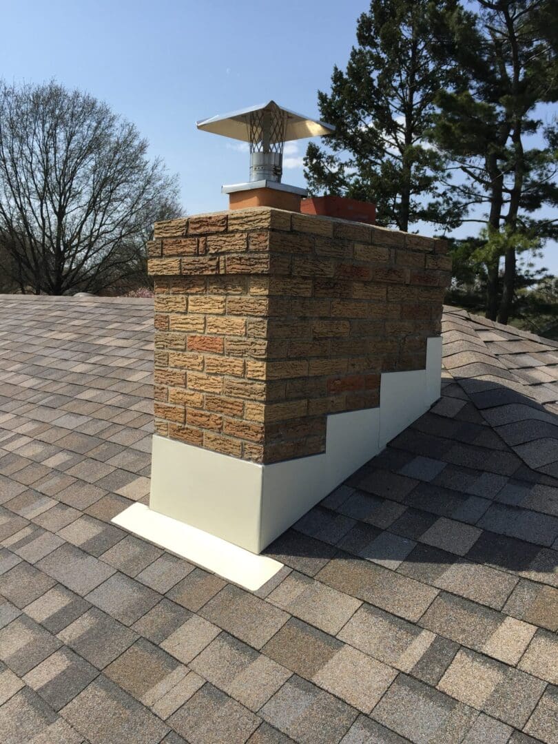 A brick chimney with new cream colored flashing.