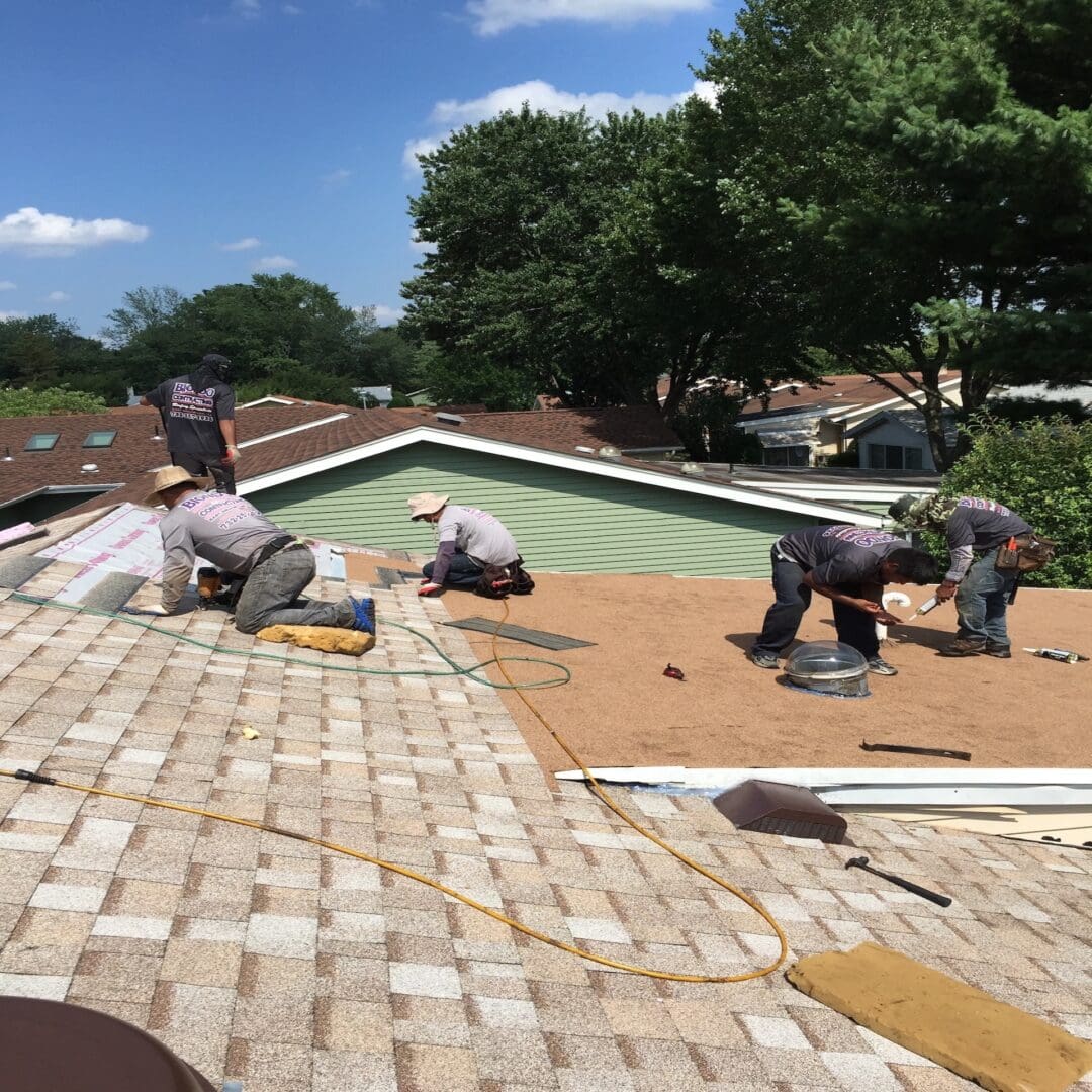 A group of men working on the roof of a house.