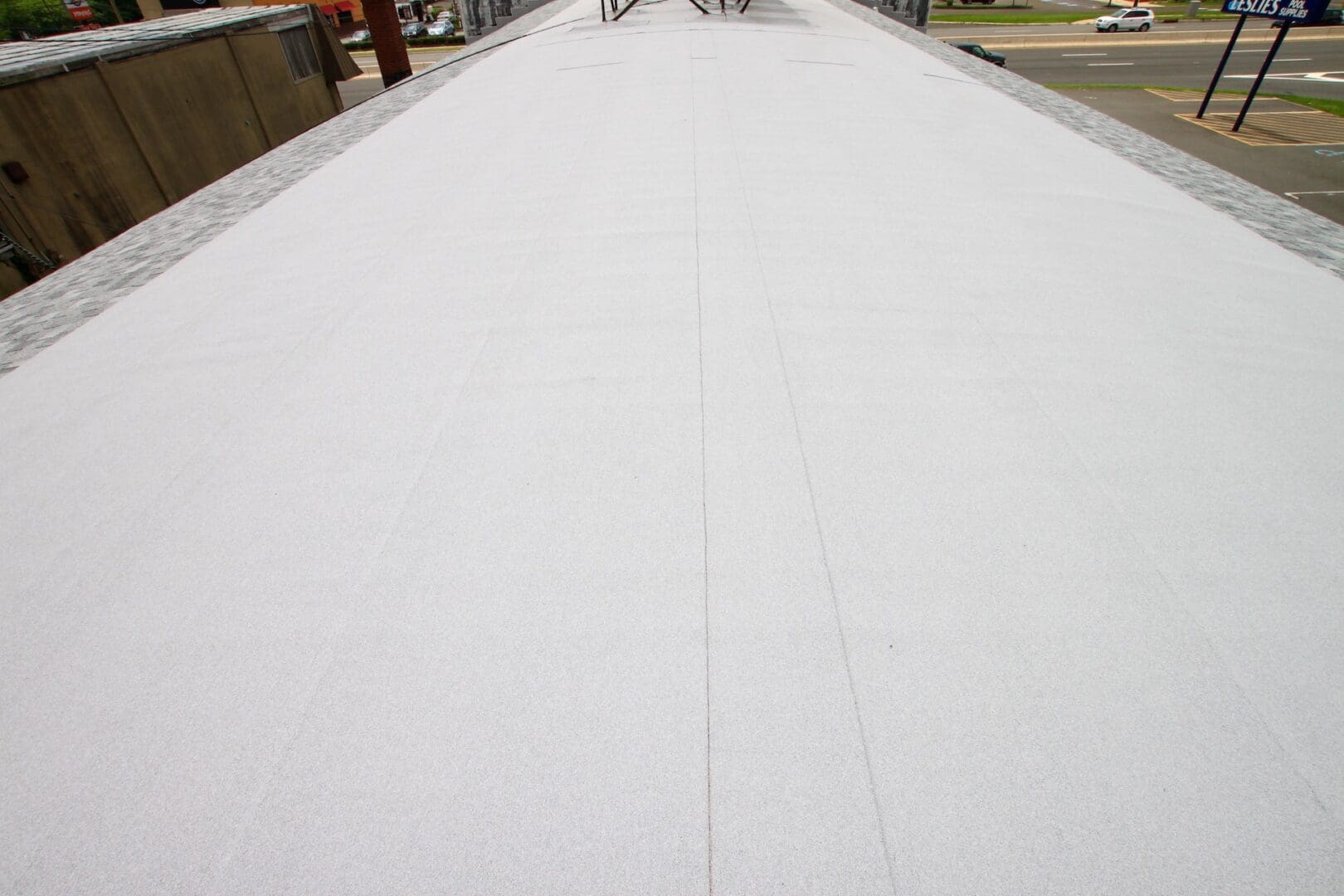 A white sheet granulated flat roof on top of a large building.