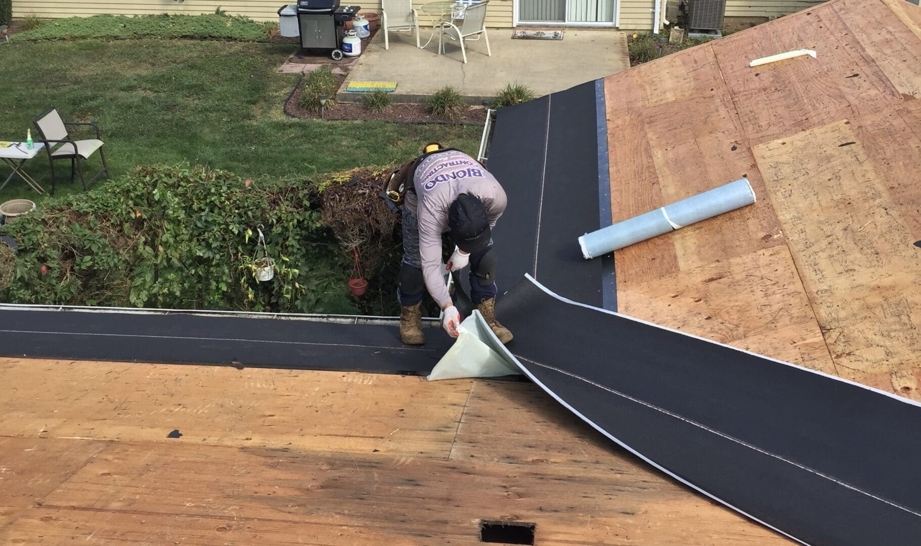 A man working on the roof of a house