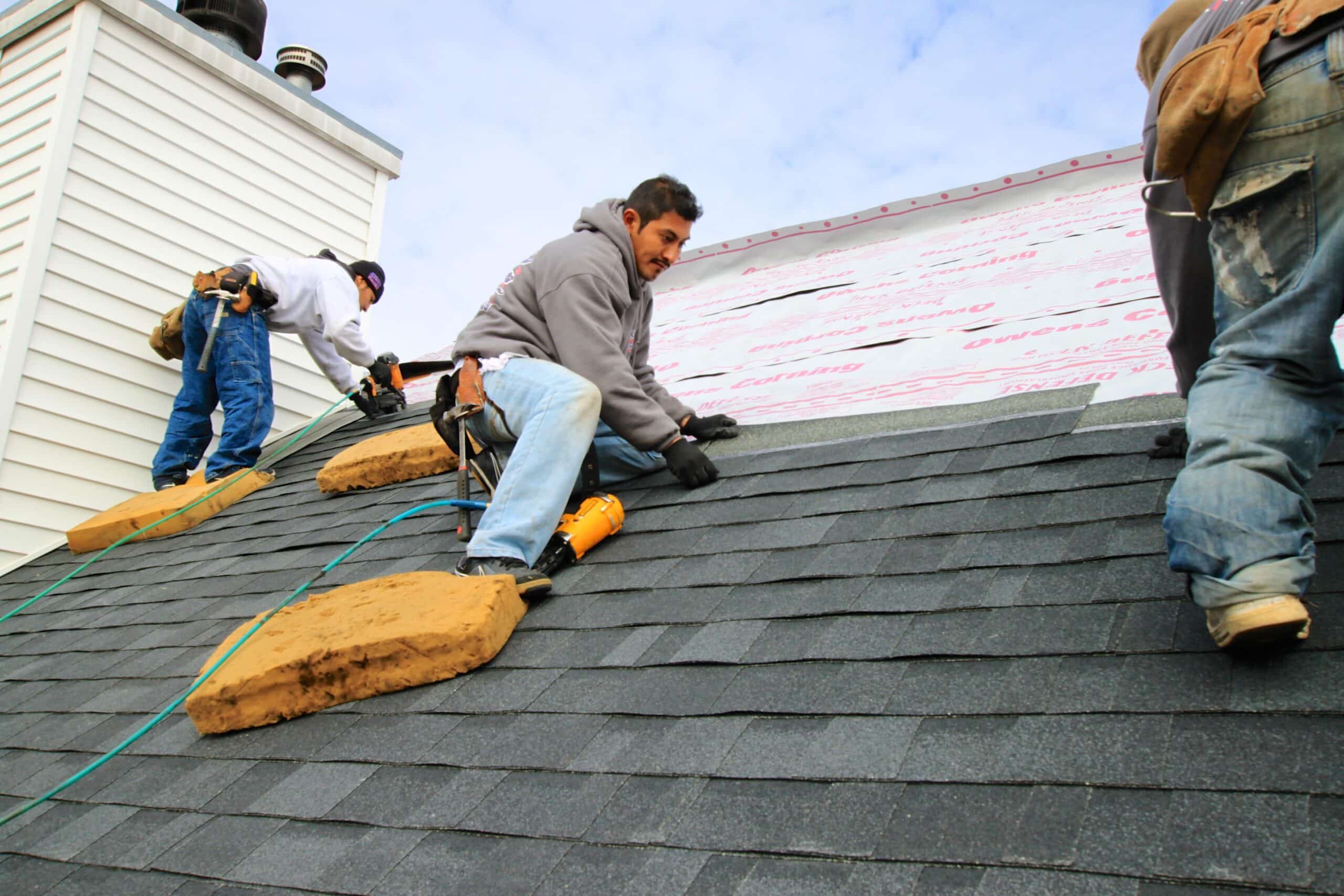 Men working on the roof of a large house
