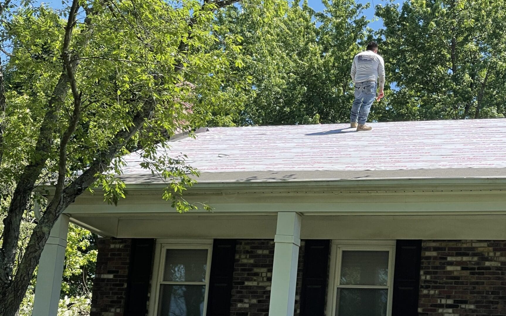 A man standing on the roof of a house.