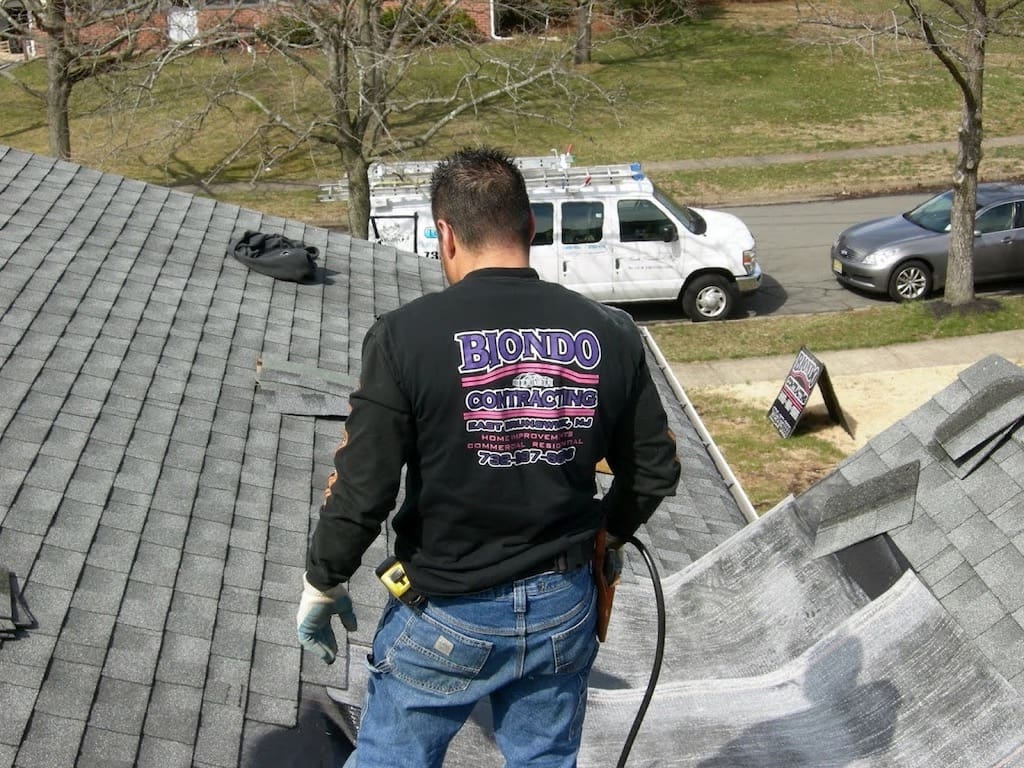 A man is working on the roof of a home.