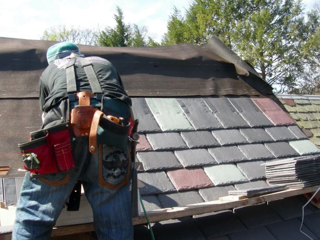A man with a backpack and tools on his back. Monroe NJ Roof repair