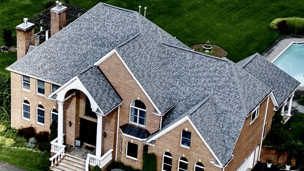A house with a large roof that is covered in vibrant color shingles. Monroe NJ Roofing Experts