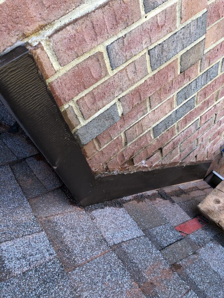 Old Bridge Roofers Counter flashing installed along the corner of a red brick wall